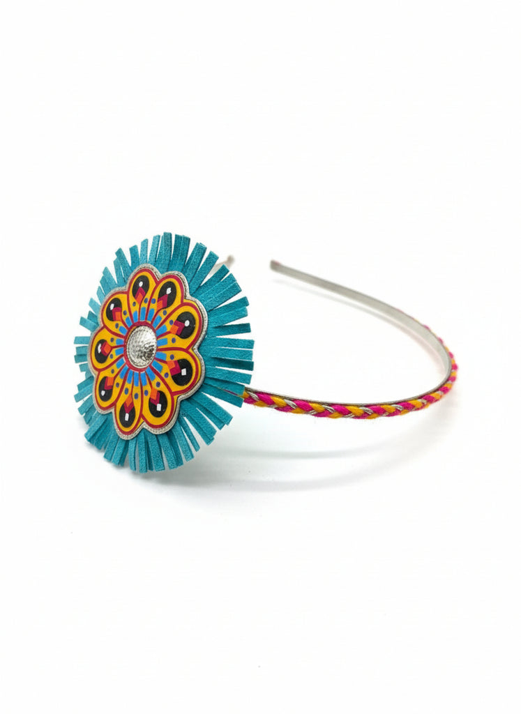 Decorative headband with a blue floral design on a wooden surface