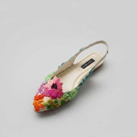 A pair of pointed-toe slingback flats by Chapter 13, decorated with vibrant pink, orange, and green beaded floral designs on a light beige insole, displayed on a wooden surface.
